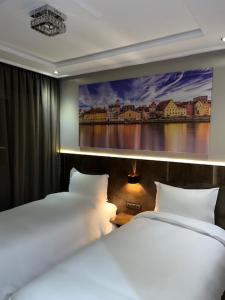 Hotel Appartement Tanger في طنجة: سريرين في غرفة مع لوحة على الحائط