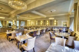 uma sala de jantar cheia de mesas e cadeiras em Best Western Inverness Palace Hotel & Spa em Inverness