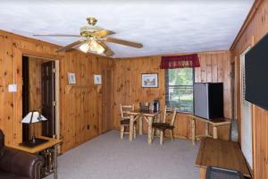 ein Wohnzimmer mit einem Deckenventilator und einem Tisch in der Unterkunft Great Pines in Old Forge