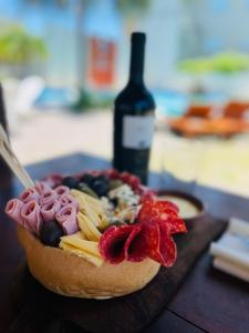 - un petit gâteau avec des fruits sur une table et une bouteille de vin dans l'établissement Hotel Termal Emperatriz, à Termas de Río Hondo