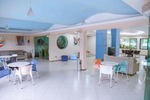 Hotel Praia Ponta d'Areia في ساو لويس: غرفة بها طاولات وكراسي وأريكة