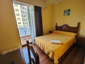 1 dormitorio con cama y ventana grande en Pensión Residencia Buenos Aires en Vigo