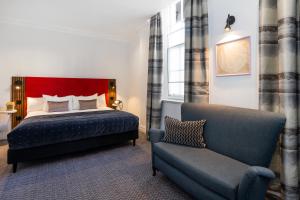 een slaapkamer met een bed, een bank en een stoel bij The Berkeley Square Hotel Bristol in Bristol