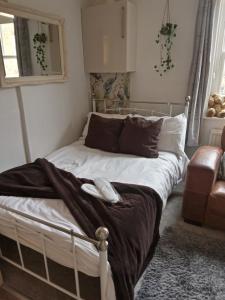 Una cama con un teléfono en un dormitorio en Little Dorrit Studio flat Rochester ME1 1XZ, en Strood
