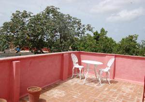 a patio with two chairs and a table on a red wall at Hostal Bitton Appartement 3 in Trinidad
