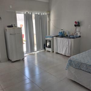 um quarto com uma cozinha com uma mesa e um fogão em Edícula no centro de VR em Volta Redonda