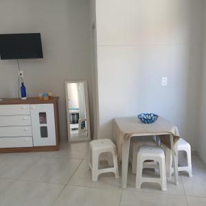 uma mesa e bancos num quarto com um espelho em Edícula no centro de VR em Volta Redonda