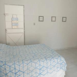 a bedroom with a bed with a blue and white comforter at Edícula no centro de VR in Volta Redonda