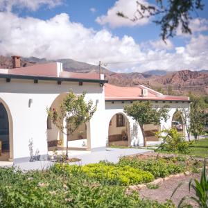 una casa blanca con montañas en el fondo en Bella Tilcara Boutique Hotel en Tilcara