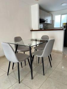 una mesa de cristal con 4 sillas en la cocina en Apartamento amoblado en Restrepo, en Restrepo