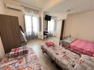 a room with two beds and a couch at Casa Tziu Predu - Centro Nuoro - B&Brothers in Nuoro