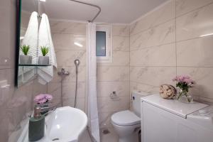 a white bathroom with a toilet and a sink at Helena's Apartment in Corfu town in Corfu Town