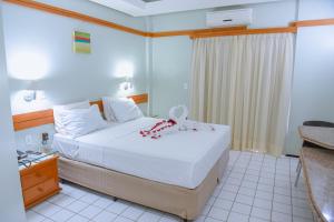 a hotel room with a bed with a bow on it at Hotel Praia Ponta d'Areia in São Luís