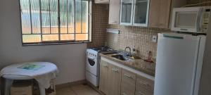 a small kitchen with a sink and a refrigerator at Apt(2) no centro de VR tudo perto até 7 pessoas in Volta Redonda