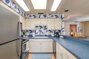 a kitchen with white cabinets and blue and white tiles at 62 Hypolita Carriage House in Saint Augustine