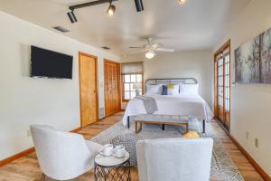 a bedroom with a bed and two chairs and a tv at 62 Hypolita Carriage House in St. Augustine