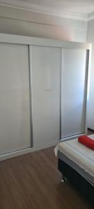 a bedroom with sliding glass doors on a bed at Apt(2) no centro de VR tudo perto até 7 pessoas in Volta Redonda