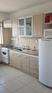 a kitchen with a stove and a sink and a refrigerator at Apt(2) no centro de VR tudo perto até 7 pessoas in Volta Redonda
