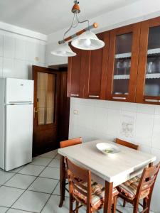 a kitchen with a table and a white refrigerator at Appartamento Dimora dei marchi in Cosenza