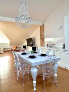 a dining room with a white table and chairs at Divon Luxury Apartments by Wawel Castle in Krakow