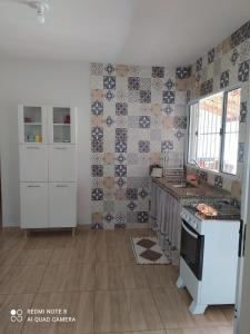 eine Küche mit weißen Geräten und Wandfliesen in der Unterkunft Casa acolhedora, bem aconchegante com piscina. in Brotas