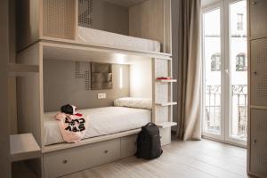 sypialnia z łóżkiem piętrowym w pokoju z oknem w obiekcie room00 Salvador Hostel w Sewilli