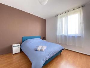 um quarto com uma cama azul e uma janela em L'ISKANDER - Apaisant 3 chambres 