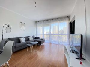 uma sala de estar com um sofá e uma televisão em L'ISKANDER - Apaisant 3 chambres 