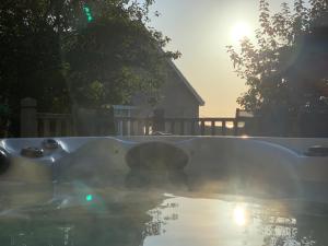 a hot tub in a yard with the sun setting at Lovely cottage in Snowdonia, private hot tub, by mountains & award winning beach in Fairbourne
