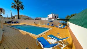 a swimming pool with lounge chairs and a swimming pool at Villa Gilsónia by Sunny Deluxe in Guia