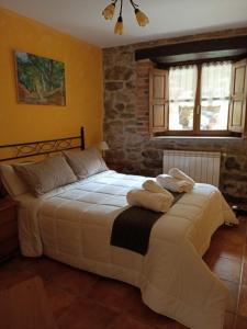 a bedroom with a large bed with towels on it at Carroceu Rural in Cangas de Onís