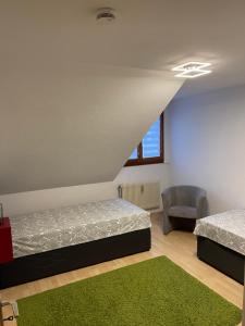 2 Betten in einem Zimmer mit grünem Teppich in der Unterkunft Casa Catalina in Rust