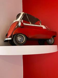 un coche de juguete rojo sentado en la parte superior de un estante blanco en Marina View en Newcastle