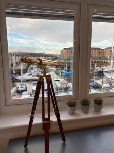 un telescopio su un treppiede di fronte a una finestra di Marina View a Newcastle upon Tyne
