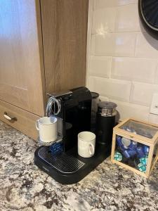 a coffee maker on a counter with two coffee cups at Marina View in Newcastle upon Tyne
