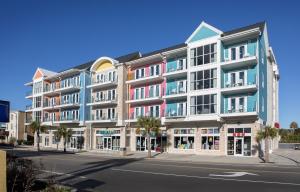- un grand bâtiment dans une rue bordée de palmiers dans l'établissement Ocean Escape Condos, à Myrtle Beach