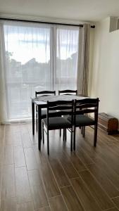 una sala da pranzo con tavolo, sedie e finestra di Depto a pasos del centro de Puerto Montt a Puerto Montt
