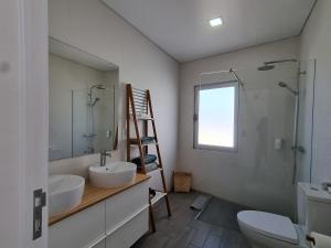 ein Badezimmer mit zwei Waschbecken, einem WC und einer Leiter in der Unterkunft Bay House - Sealife Apartment in Ponta Delgada