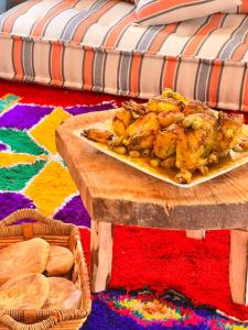 a plate of food on a table with a couch at Dar Khalti - Cascades - Piscine - Montagne in Ouzoud