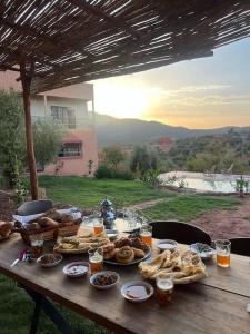 a picnic table with food and drinks on it at Dar Khalti - Cascades - Piscine - Montagne in Ouzoud
