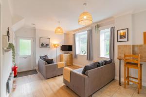 a living room with two couches and a table at The Peak by Afan Valley Escapes in Cymmer