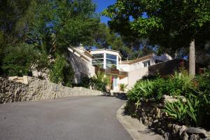 a house with a stone wall and a driveway at B&B Villa Castelnau Montpellier in Castelnau-le-Lez