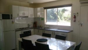 una piccola cucina con tavolo e finestra di Phillip Island Cottages a Cowes