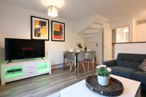 a living room with a couch and a table at Luxury 4 Bed House with Gated Parking in the Heart of Birmingham! in Birmingham