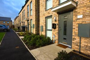 a brick building with a door next to a street at Luxury 4 Bed House with Gated Parking in the Heart of Birmingham! in Birmingham