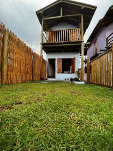 uma casa com uma cerca e um jardim de relva em Chalé Lampião Caraiva em Caraíva