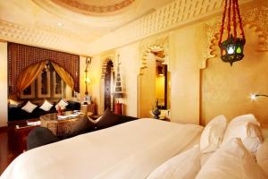 a bedroom with a white bed and a living room at Sawasdee Village in Kata Beach