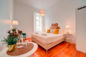 a bedroom with a large bed and a table at Chalet D´Ávila Guest House in Lisbon