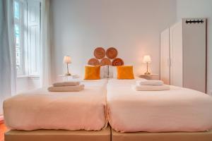 duas camas grandes num quarto com duas lâmpadas em Chalet D´Ávila Guest House em Lisboa