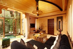 a living room with a couch and a table at Sawasdee Village in Kata Beach